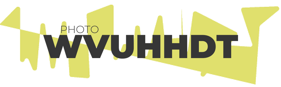 Graphic text banner displaying the word PHOTO in a thin black sans-serif font positioned directly above WVUHHDT in bold, dark gray sans-serif lettering. The text is set against a background of spiky abstract yellow geometric shapes on a solid white field.